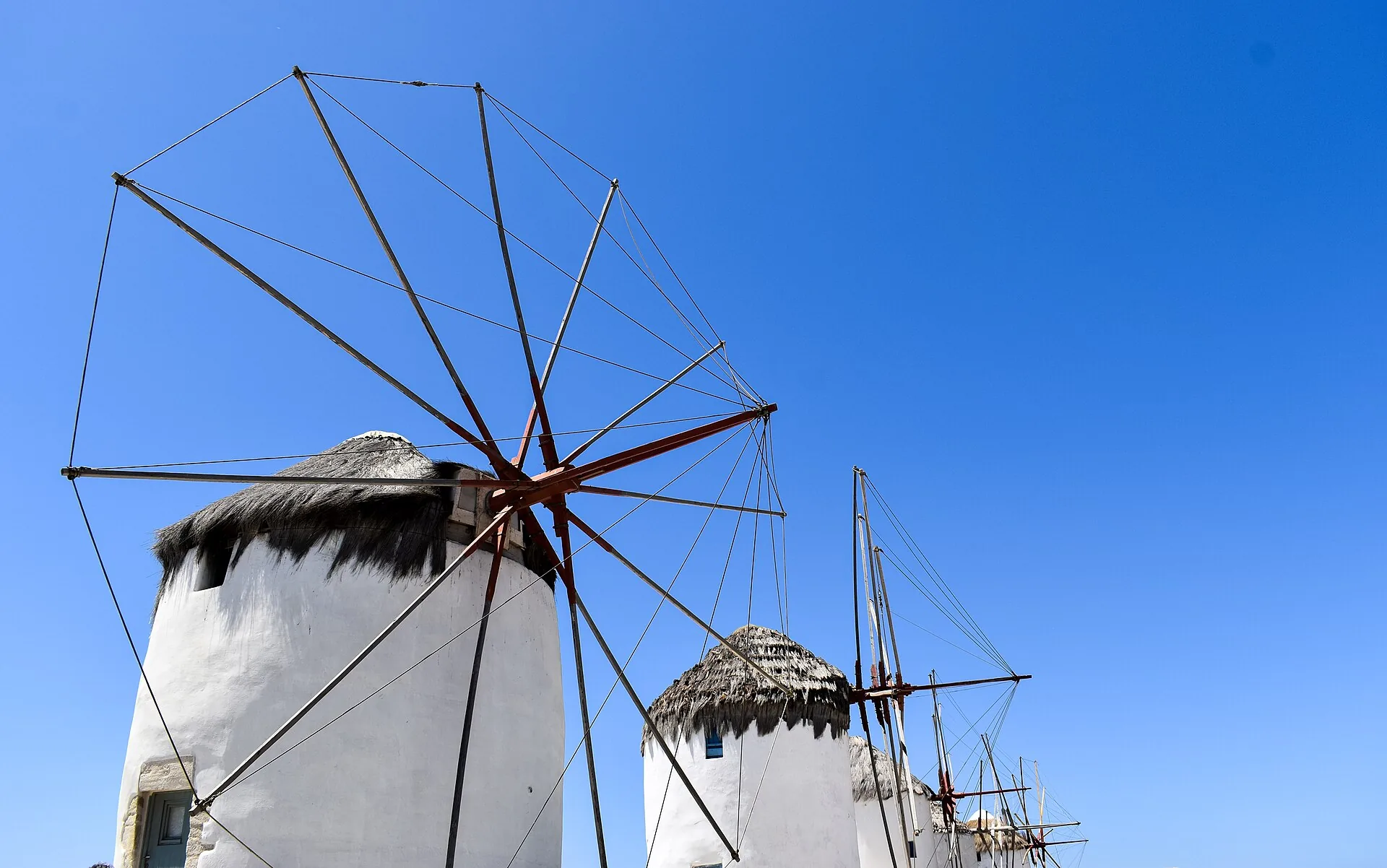 The iconic row of whitewashed windmills above the sea in Mykonos, Greece