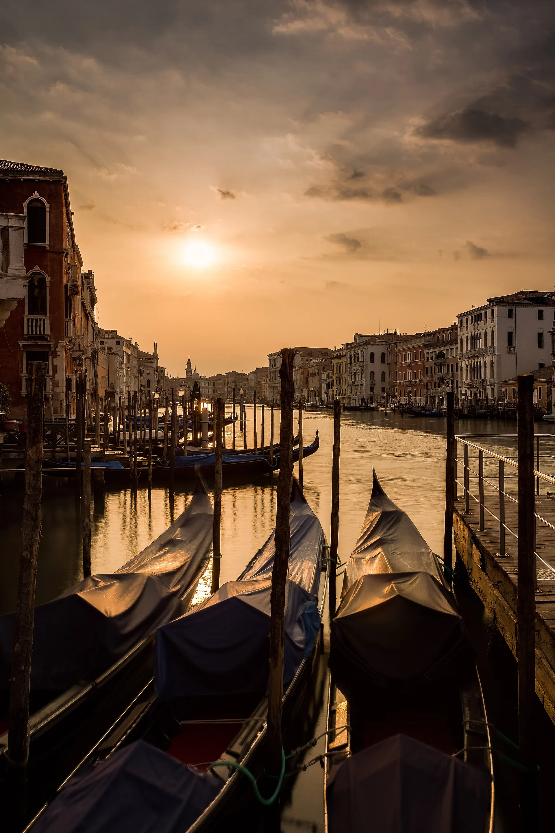Early morning light on a quiet Venice canal with gondolas moored along the water